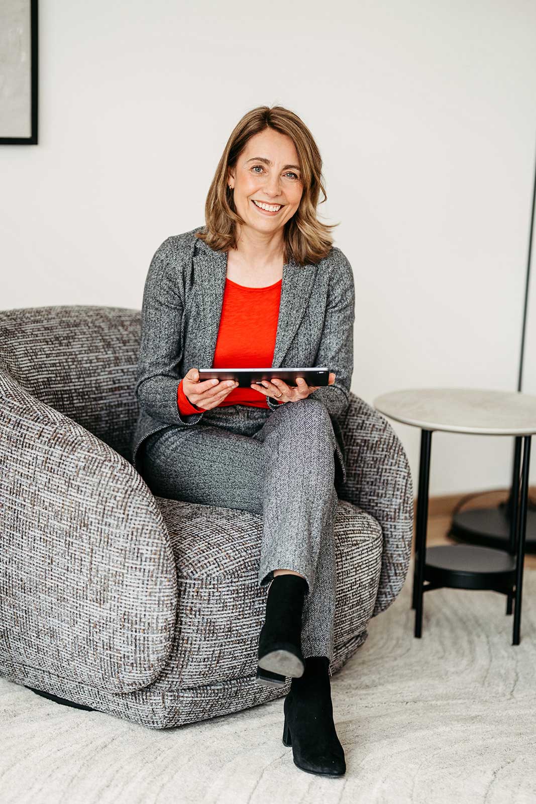 Frau sitzend mit Tablet in der Hand